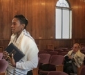Rabbi Sandra Lawson holding a prayer book and wearing a prayer shawl. (Curtesy Rabbi Lawson)