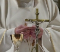 A priest holds a Communion wafer. Public domain image by István Kis via Pixabay.com
