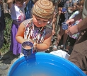 Shasta-Trinity National Forest, CA—The granddaughter of Chief Caleen Sisk holds salmon eggs before dropping them into an incubator (the blue barrel) where they will hatch and juvenile salmon will swim out into the McClou